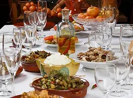 Una mesa cubierta con platos de comida y copas de vino.