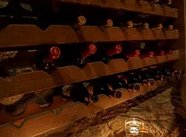 Una bodega llena de botellas de vino y una vela.