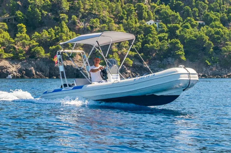 Un hombre conduce un barco en el océano.