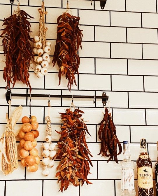 Una botella de Terry reposa sobre una pared de azulejos blancos.