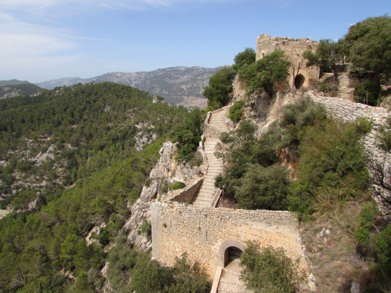 Un castillo en la cima de una colina con escaleras que conducen a él.