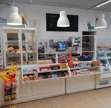 Una panadería con un osito de peluche en el mostrador.