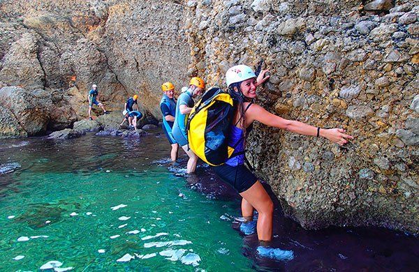 Un grupo de personas camina a través de un cuerpo de agua.