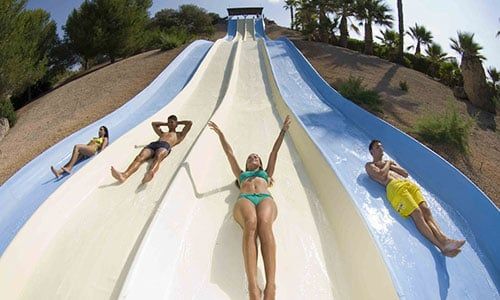 Un grupo de personas se desliza por un tobogán de agua en un parque acuático.