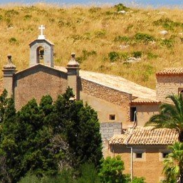 Una iglesia con un campanario y una cruz en la parte superior.