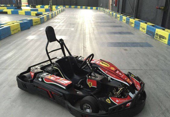 Un kart rojo y negro está en una pista de carreras.