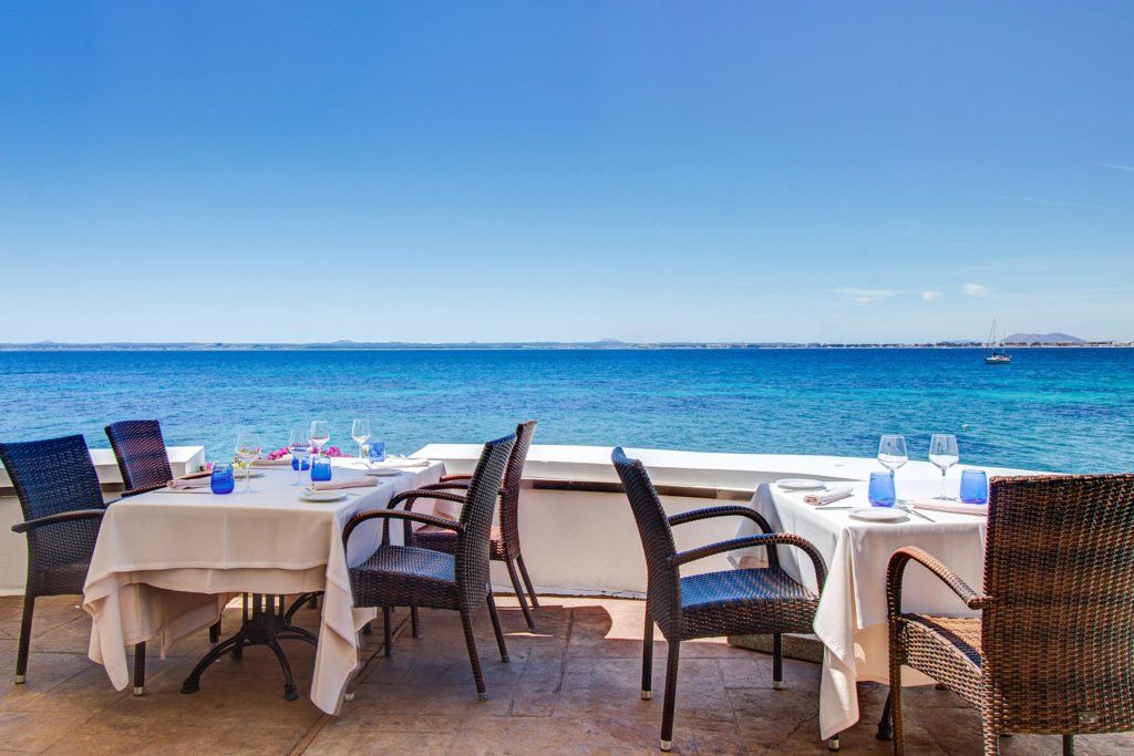 Un restaurante con mesas y sillas con vista al mar.