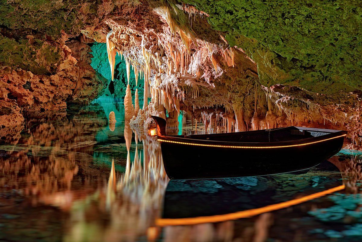 Un barco está flotando sobre un cuerpo de agua en una cueva.
