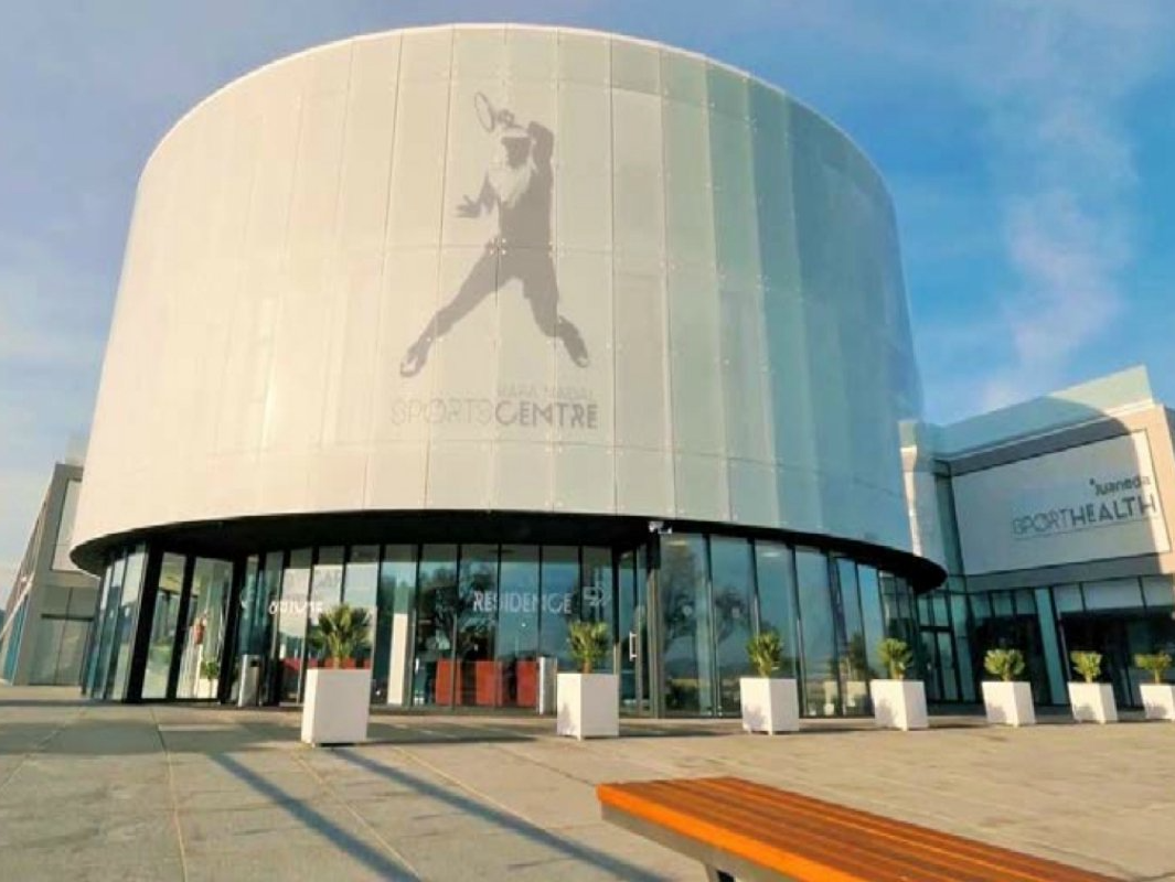 Un gran edificio blanco con la silueta de un jugador de béisbol en él.