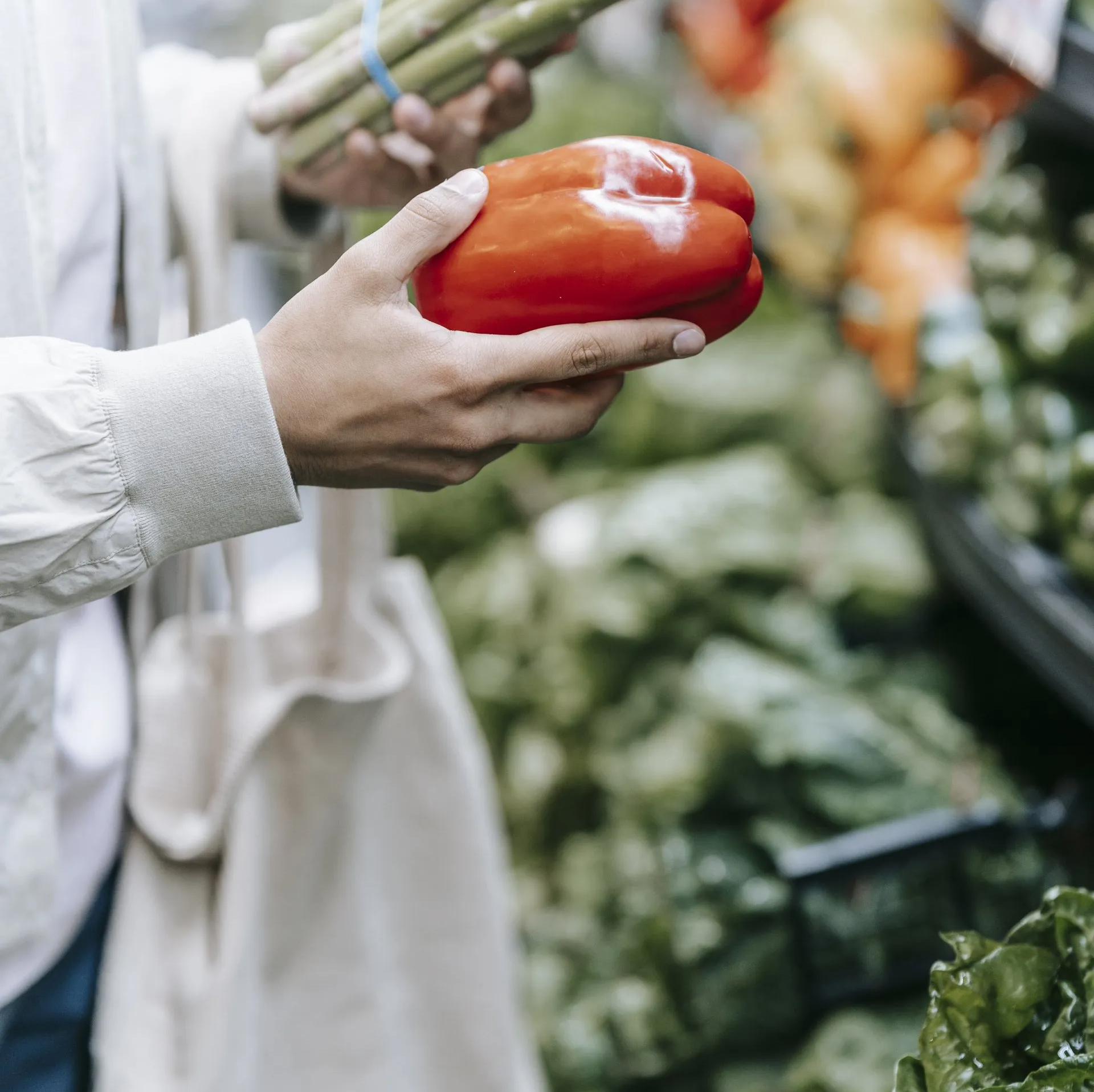 Una persona sostiene un pimiento rojo en su mano.