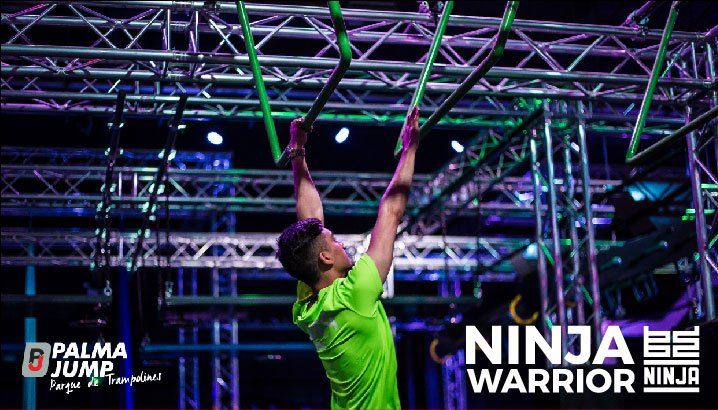 Un hombre con una camisa verde está escalando una pista de guerreros ninja.