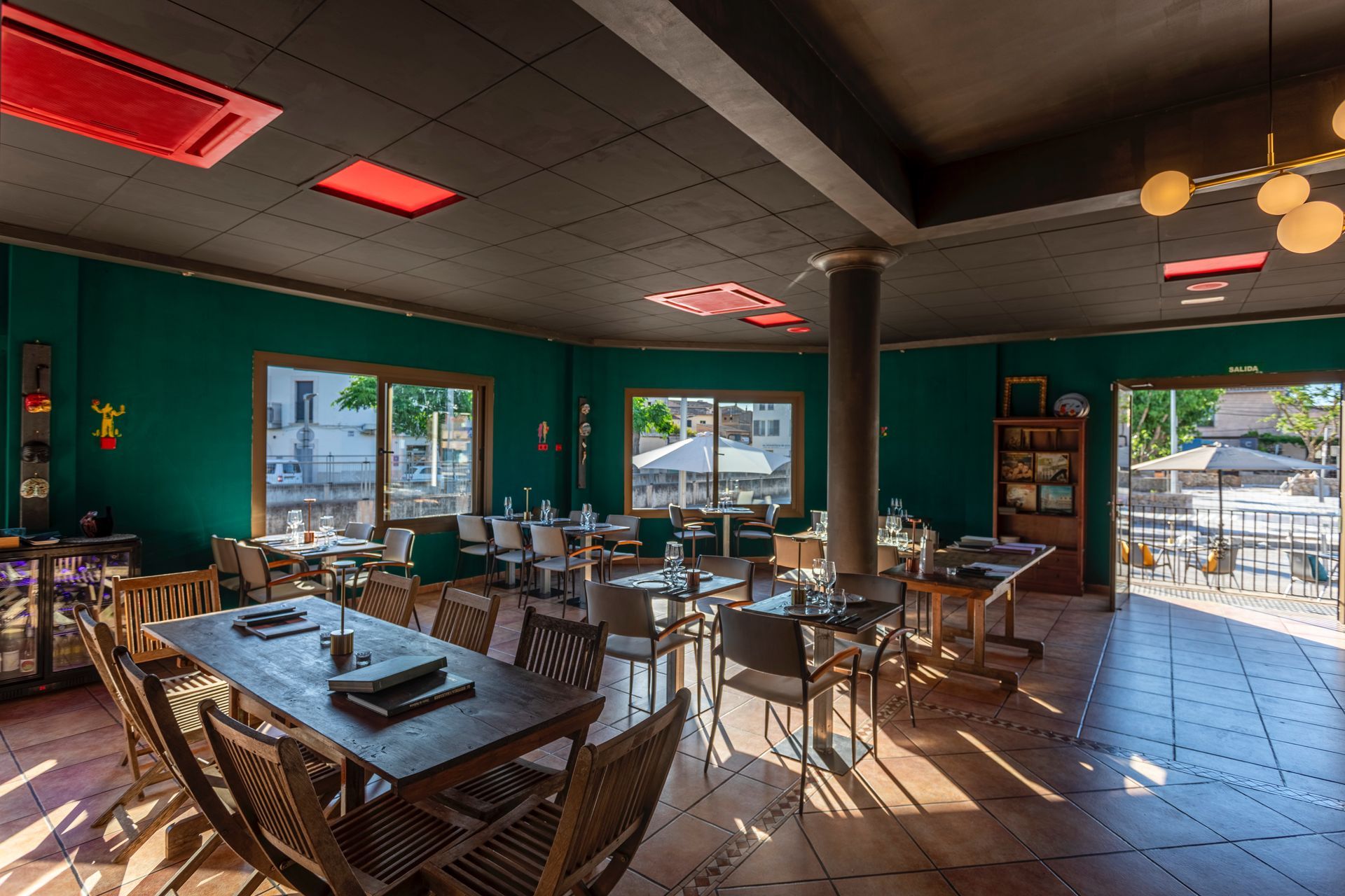 Un gran comedor con mesas y sillas y paredes verdes.