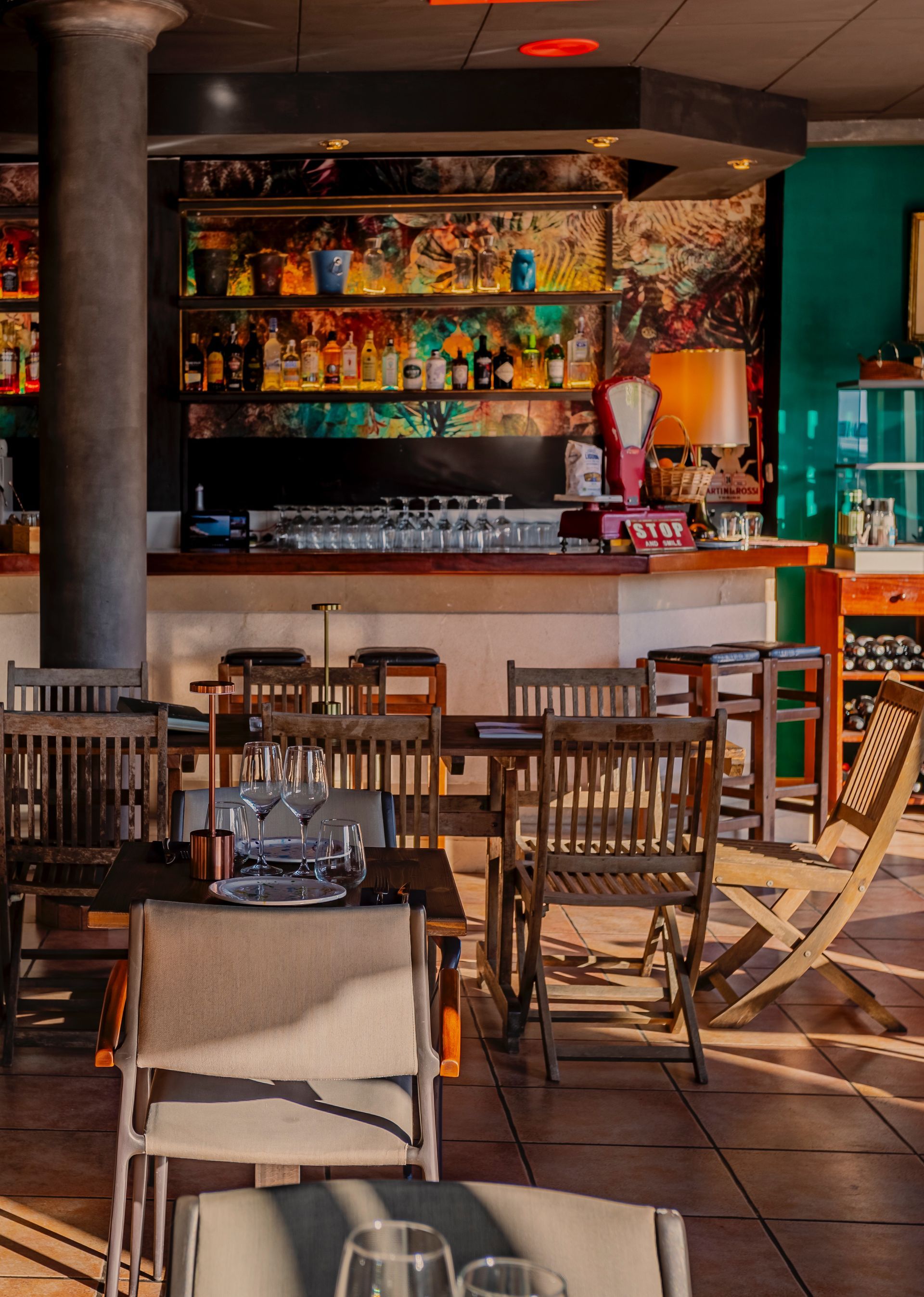Un restaurante con mesas y sillas y un bar al fondo.