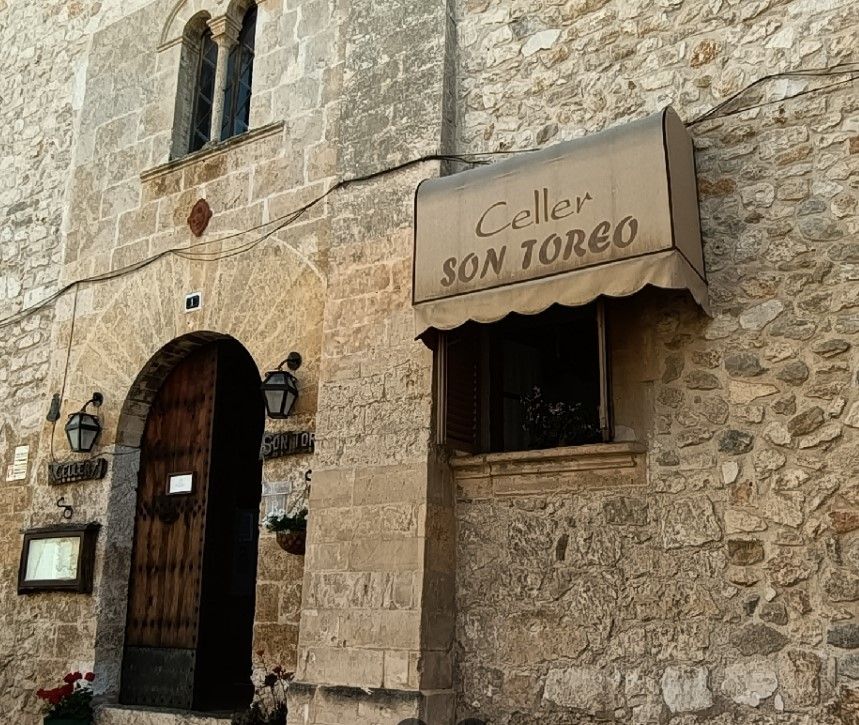 Un edificio de piedra con un cartel que dice celler son torgo