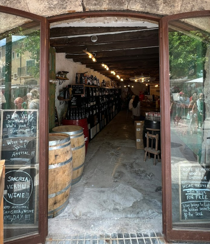 El interior de una tienda con barriles y carteles de pizarra.