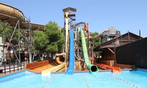 Un parque acuático con muchos toboganes y una piscina.
