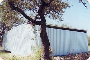 A white building with a tree in front of it