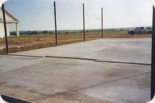 A concrete driveway with a truck parked in the background.
