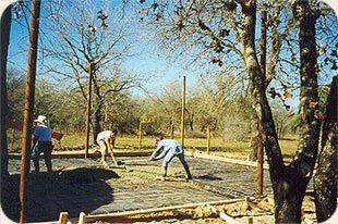 A group of people are working on a construction site in the woods.