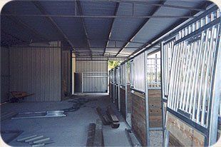 A row of horse stalls in a building under construction