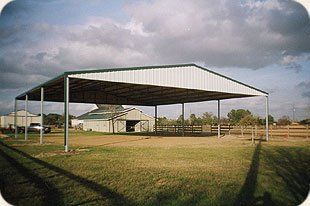 There is a large covered area in the middle of a field.
