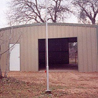 A large metal building with a flag pole in front of it.