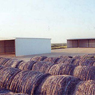 A bunch of hay bales are stacked on top of each other in a field.
