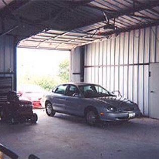 A car is parked in a garage with the door open.