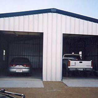 Two cars and a truck are parked in a garage.
