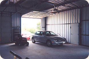 A car is parked in a garage with the door open