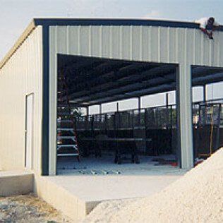 A man is working on the roof of a metal building.