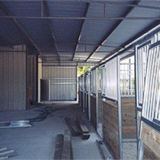 A row of horse stalls in a building under construction