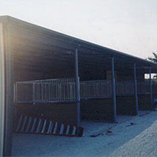 A large building with a covered porch and a ramp in front of it.