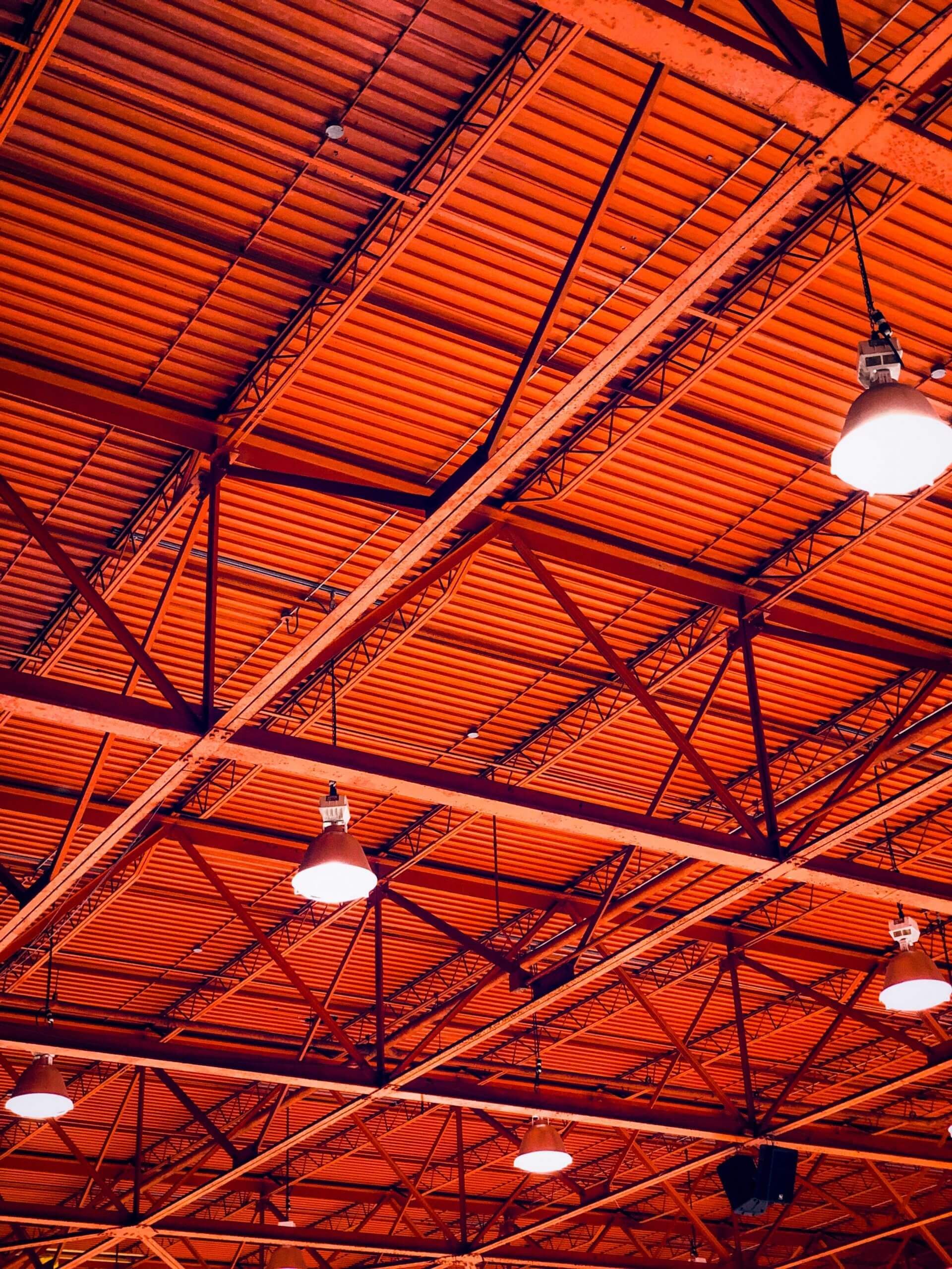 A close up of the ceiling of a building with lights hanging from it