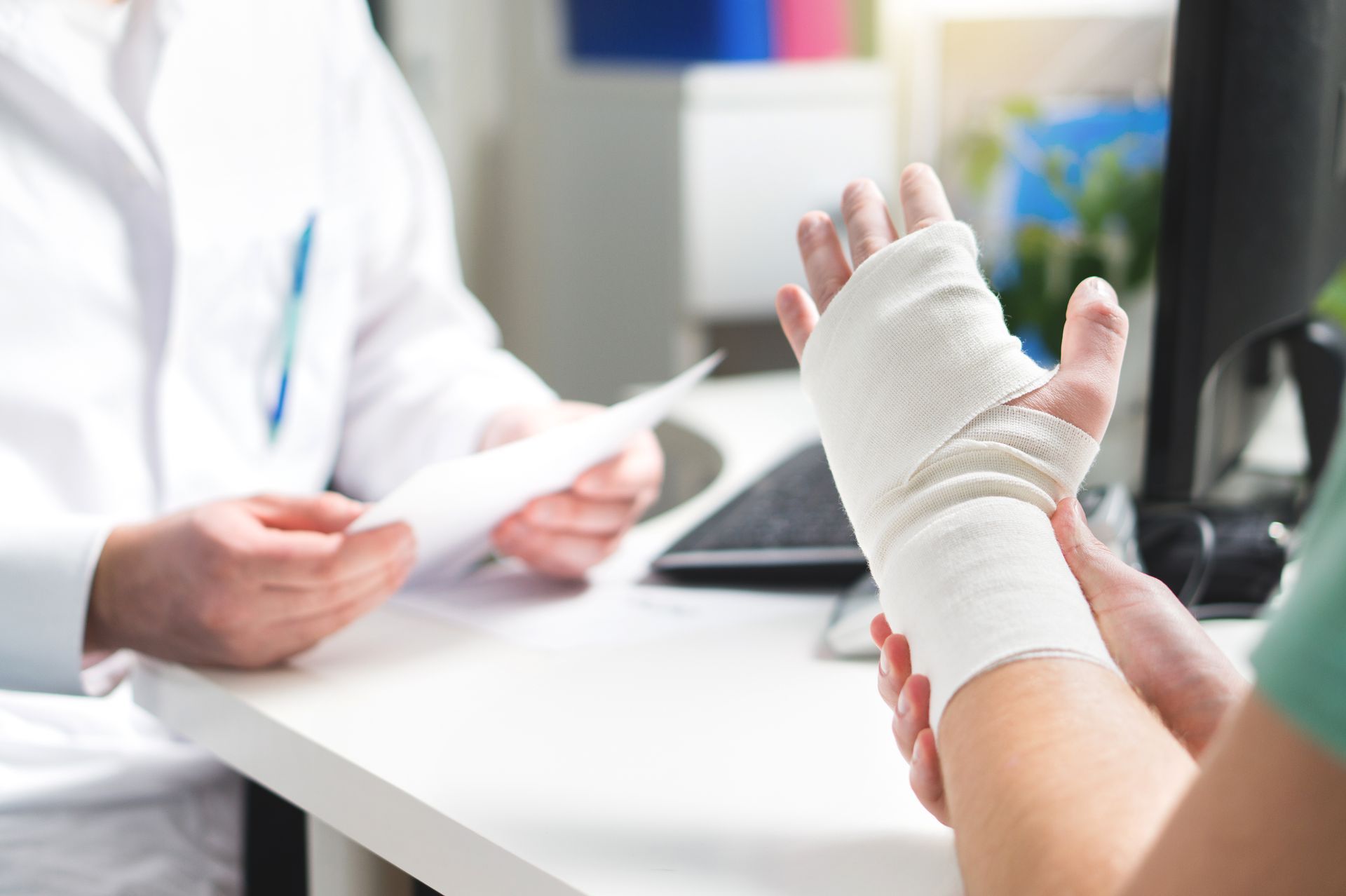 Bandaged hand held up during a doctor’s office consultation