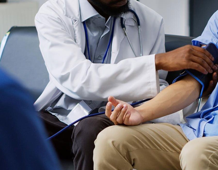 Doctor taking a patient's blood pressure in a clinic waiting area
