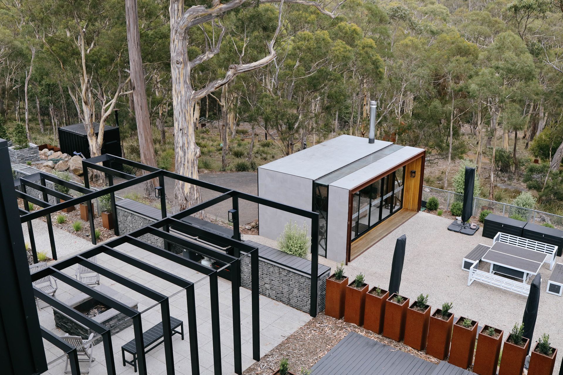 An aerial view of a house in the middle of a forest.