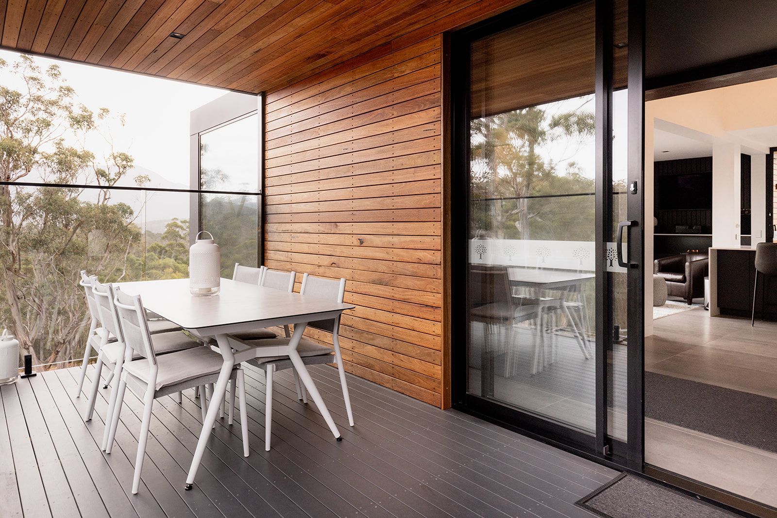 A patio with a table and chairs and a sliding glass door.