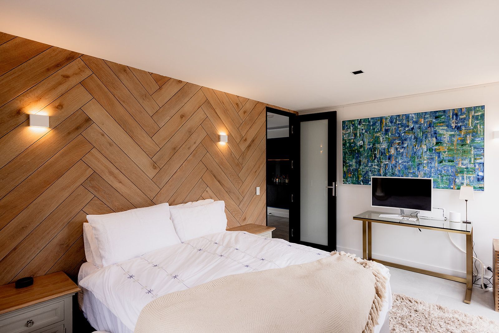 A bedroom with a large bed and a wooden wall.