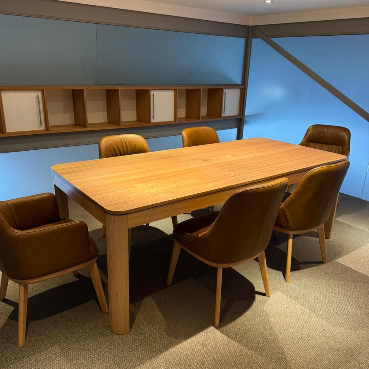 A wooden table and chairs in a room with blue walls