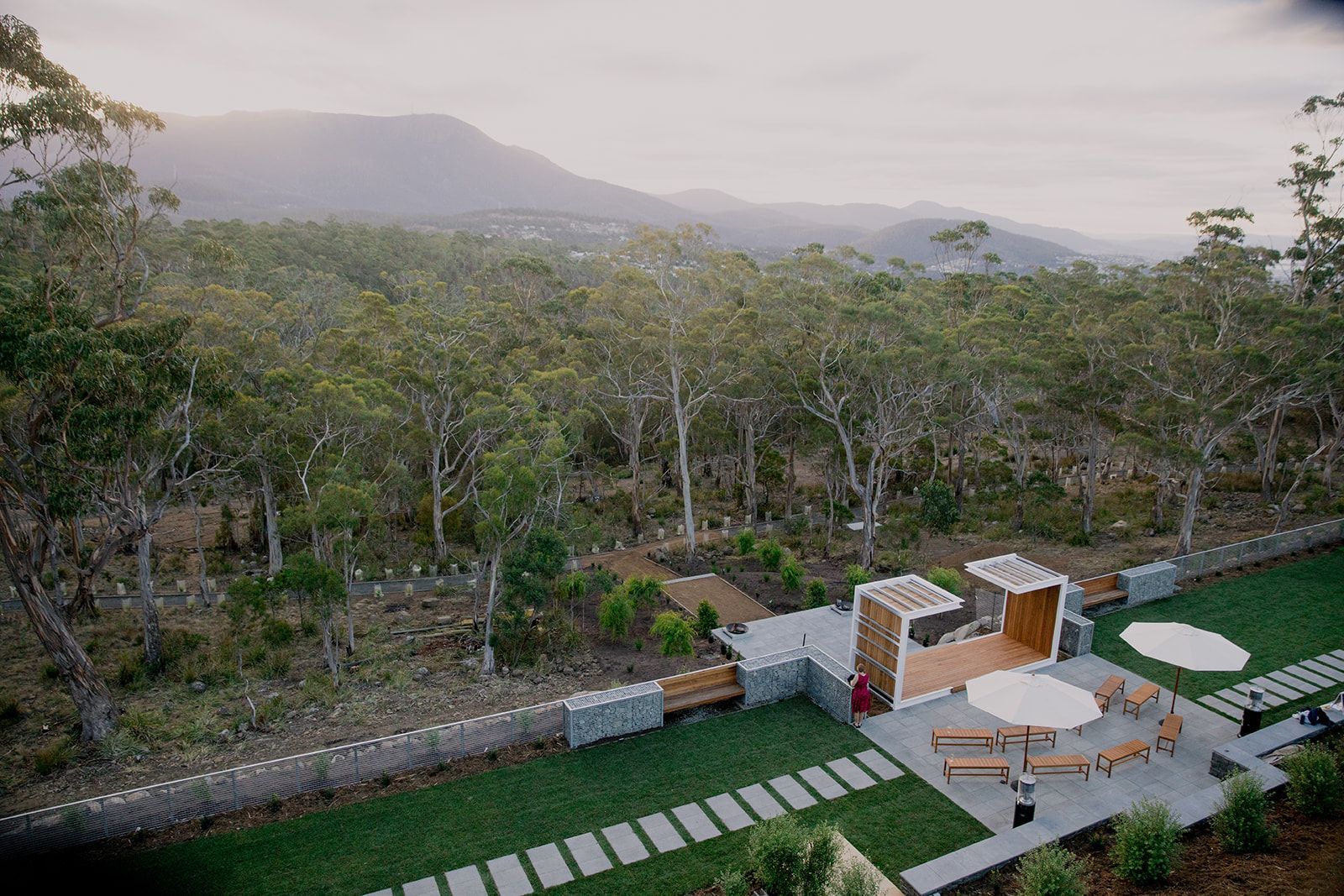 An aerial view of a house in the middle of a forest.