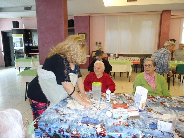 donne anziane assistono alla preparazione della pasta fatta in casa