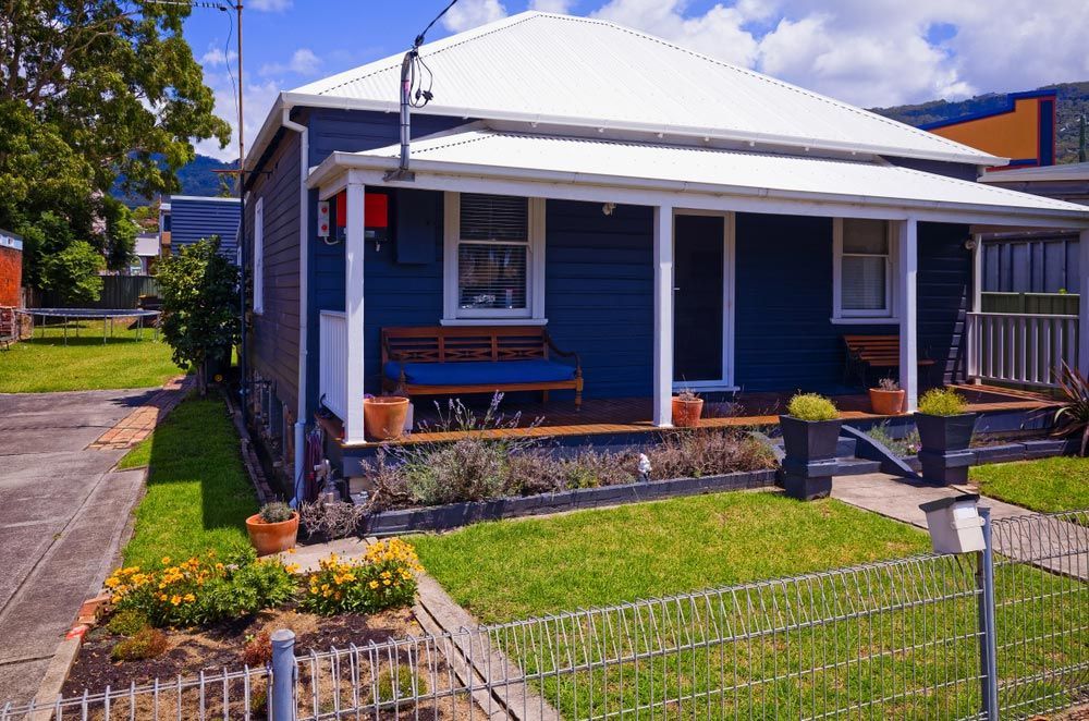 A Blue House with A White Roof and A Porch — Glen Lamberts Wall Cladding & Home Improvements in Port Macquarie, NSW