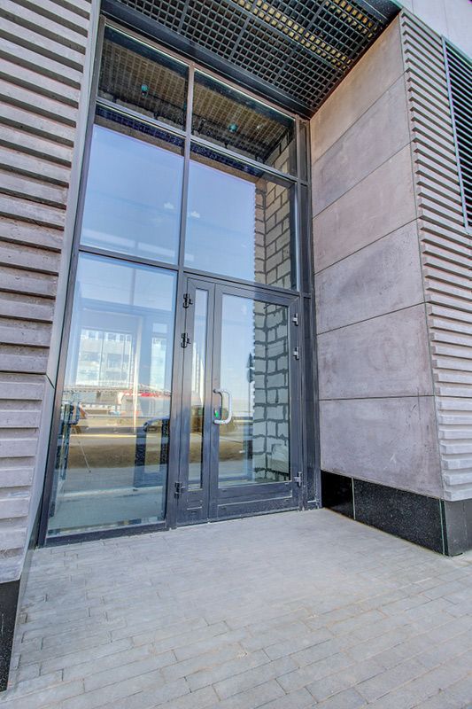 A Building With a Large Glass Door and a Brick Wall — Glen Lamberts Wall Cladding & Home Improvements in Gloucester, NSW