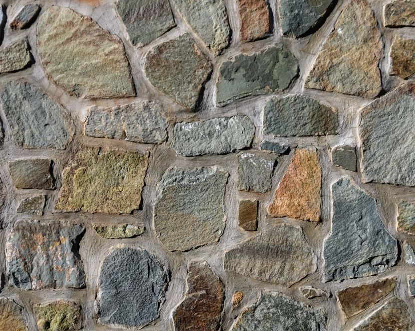 A Close Up of a Stone Wall Made of Different Colored Rocks — Glen Lamberts Wall Cladding & Home Improvements in Laurieton, NSW