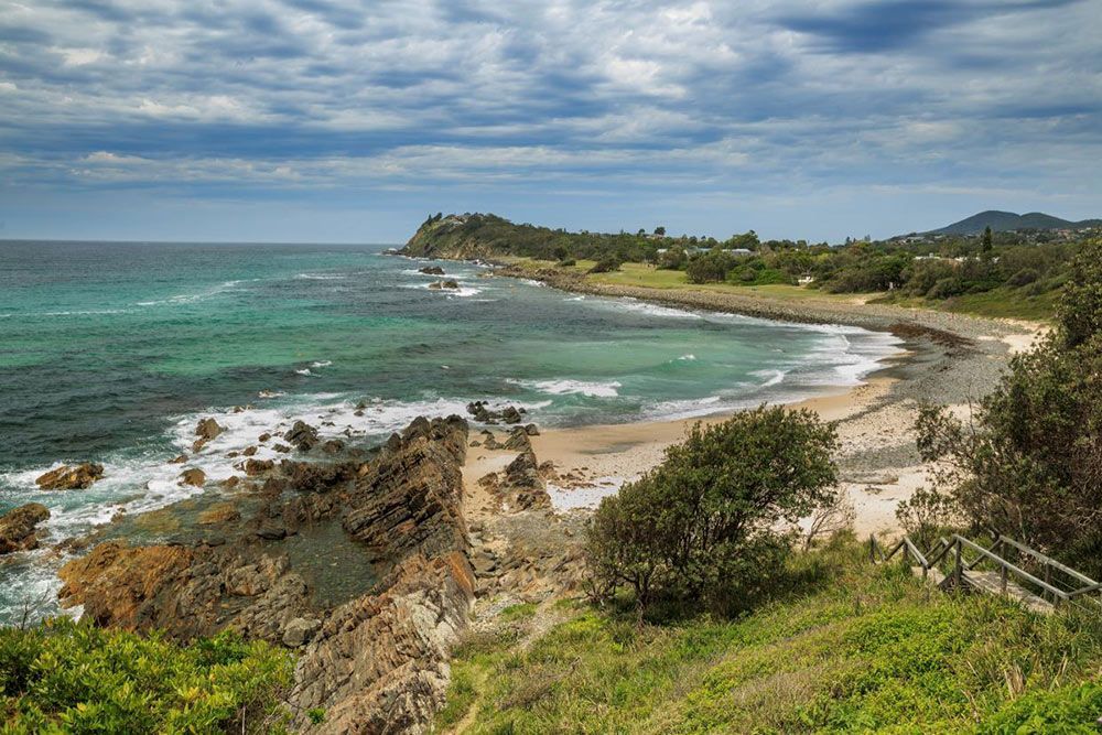 A View of a Beach From a Cliff Overlooking the Ocean — Glen Lamberts Wall Cladding & Home Improvements in Forster, NSW