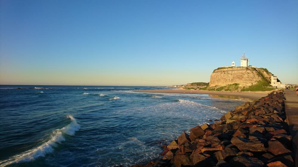 A Lighthouse on Top of a Rocky Hill Overlooking the Ocean — Glen Lamberts Wall Cladding & Home Improvements in Newcastle, NSW