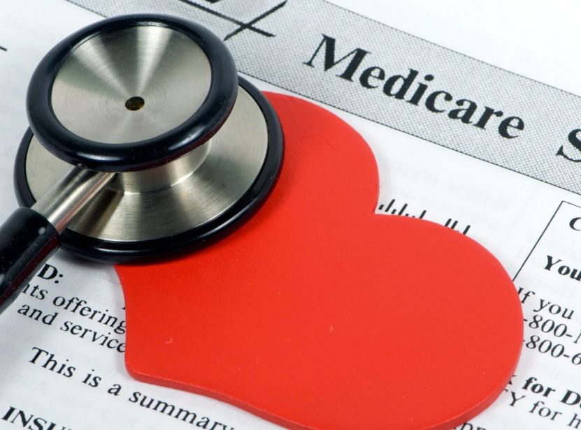 Stethoscope on a red heart-shaped object, resting on a Medicare document.