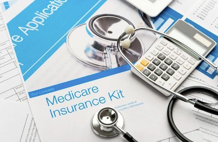 Medicare Insurance Kit with stethoscope, calculator, and application documents.