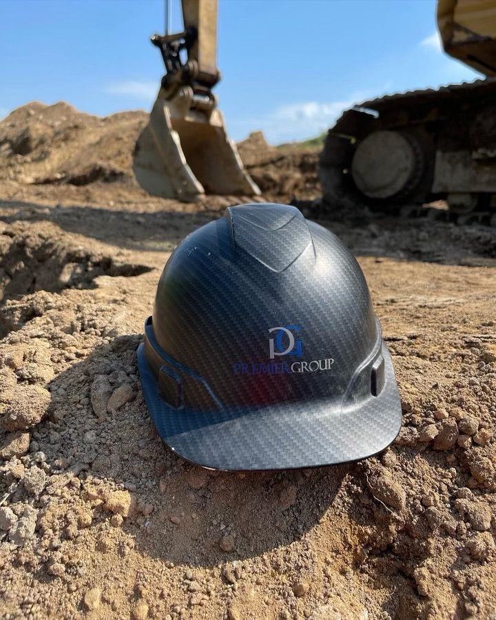 White van with ladder parked in front of a building with garage door. 